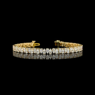 Gold tennis bracelet with 7 carats of alternating pear-shaped lab-grown diamonds, showcasing elegant jewelry design.