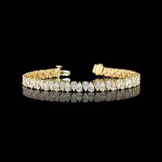 Yellow gold tennis bracelet with 60 lab-grown pear-shaped diamonds totaling 9 carats, 6.5-inch length, alternating design.