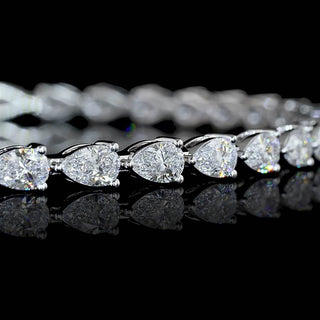 Close-up of east-west pear shaped lab grown diamond tennis bracelet, with 10 to 12-pointer pear diamonds in 14k white gold prong setting, 4 carats total. 