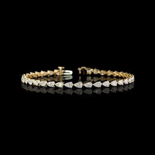 East-west pear shaped lab grown diamond tennis bracelet in 14k yellow gold prong setting, 4 carats total. 