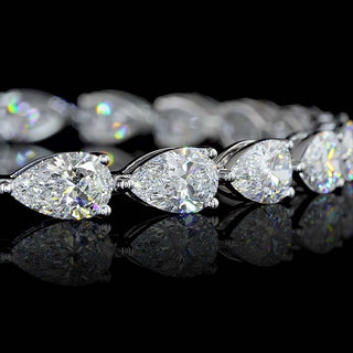 Close-up of East-West Pear-shaped lab grown diamond tennis bracelet in 14k white gold, prong setting, 12 carats total, with 50-pointer diamonds.