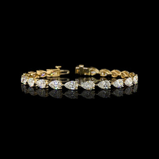 East-West Pear-shaped lab grown diamond tennis bracelet in 14k yellow gold, prong setting, 12 carats total, with 50-pointer diamonds (half carat each).