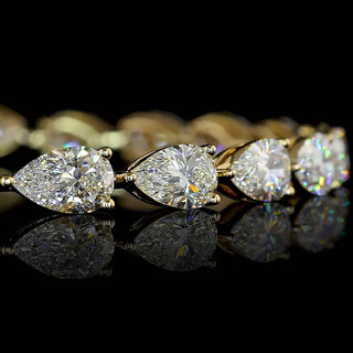 Close-up of East-West Pear-shaped lab grown diamond tennis bracelet in 14k yellow gold, prong setting, 50-pointer diamonds (half carat each).