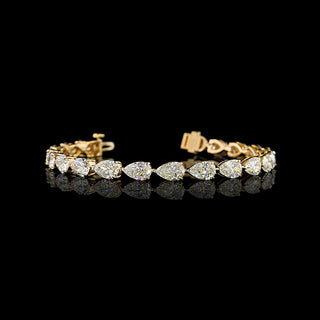 East-West Pear-shaped lab grown diamond tennis bracelet in 14k yellow gold, prong setting, 14 carats total, with 70-pointer diamonds.