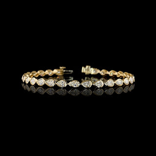 East-West Pear-shaped lab grown diamond tennis bracelet in 14k yellow gold bezel setting, 4 carats total, with 15-pointer diamonds.