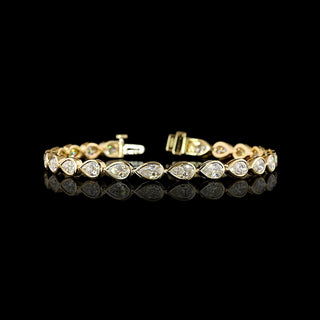  East-West Pear-shaped lab grown diamond tennis bracelet in 14k yellow gold bezel setting, 8 carats total, with 33-pointer diamonds.