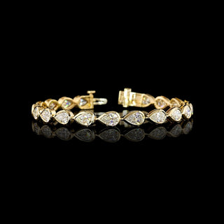 East-West Pear-shaped lab grown diamond tennis bracelet in 14k yellow gold bezel setting, 10 carats total, with 50-pointer diamonds.