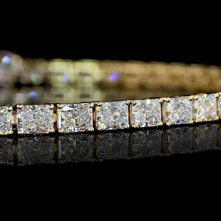 Close-up of East-West Radiant lab grown diamond tennis bracelet in 14k yellow gold prong setting.