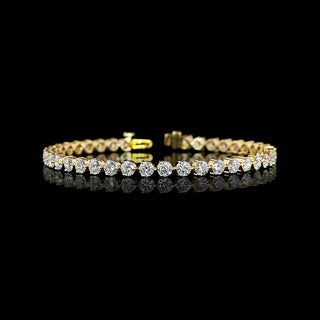 8 carat total weight lab-grown round diamond tennis bracelet with three-prong setting in yellow gold, 7-inch length.