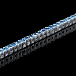 Blue round lab-grown diamond tennis bracelet with 1.5 carats total weight and 102 stones on a 7-inch white gold band.