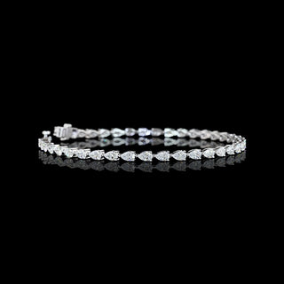 Video of east-west pear shaped lab grown diamond tennis bracelet in 14k white gold prong setting, 4 carats total. 