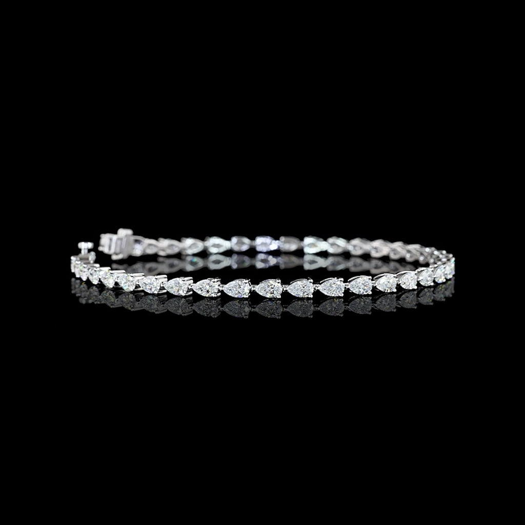 Video of east-west pear shaped lab grown diamond tennis bracelet in 14k white gold prong setting, 4 carats total. 