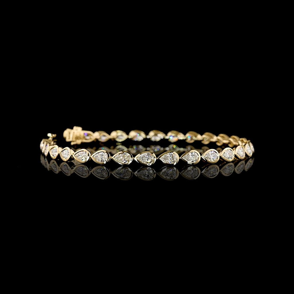 Video of East-West Pear-shaped lab grown diamond tennis bracelet in 14k yellow gold bezel setting, 4 carats total, with 15-pointer diamonds.