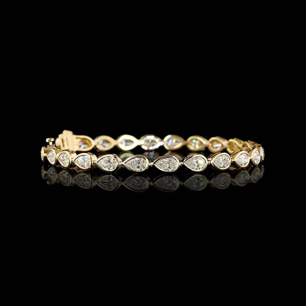 Video of East-West Pear-shaped lab grown diamond tennis bracelet in 14k yellow gold bezel setting, 8 carats total, with 33-pointer diamonds.